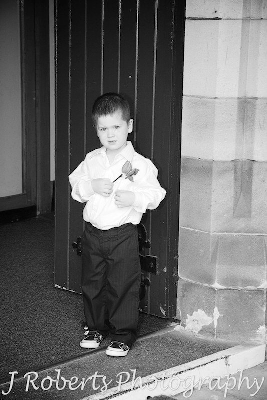 B&W of paige boy at church door - wedding photography sydney